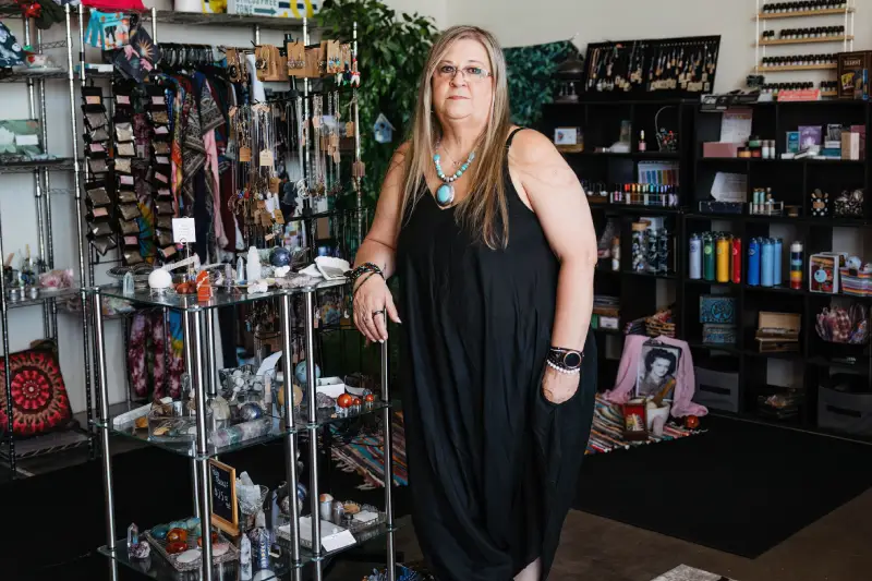 A woman stands outside a jewelry store, looking at the display window filled with sparkling jewelry items.<br />